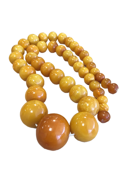 Außergewöhnlich stark graduierte SBM-Kugelkette mit kleinen End-Perlen aufsteigend zu einer massiven Mittelkugel, eierschalig-cremiges Material mit cognac-Akzenten, freigestellt
