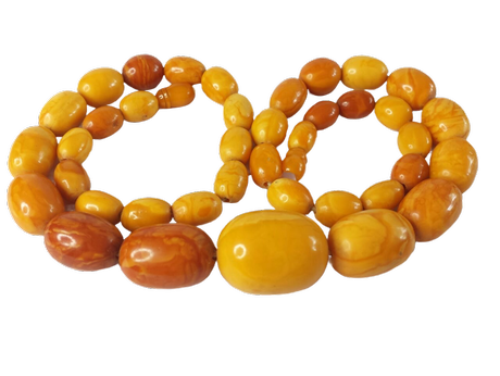 Antike SBM-Olivenkette in transparentem Honig-Butterscotch mit graduierten Perlen und charakteristischem Knotenfaden, freigestellt vor schwarzem Hintergrund