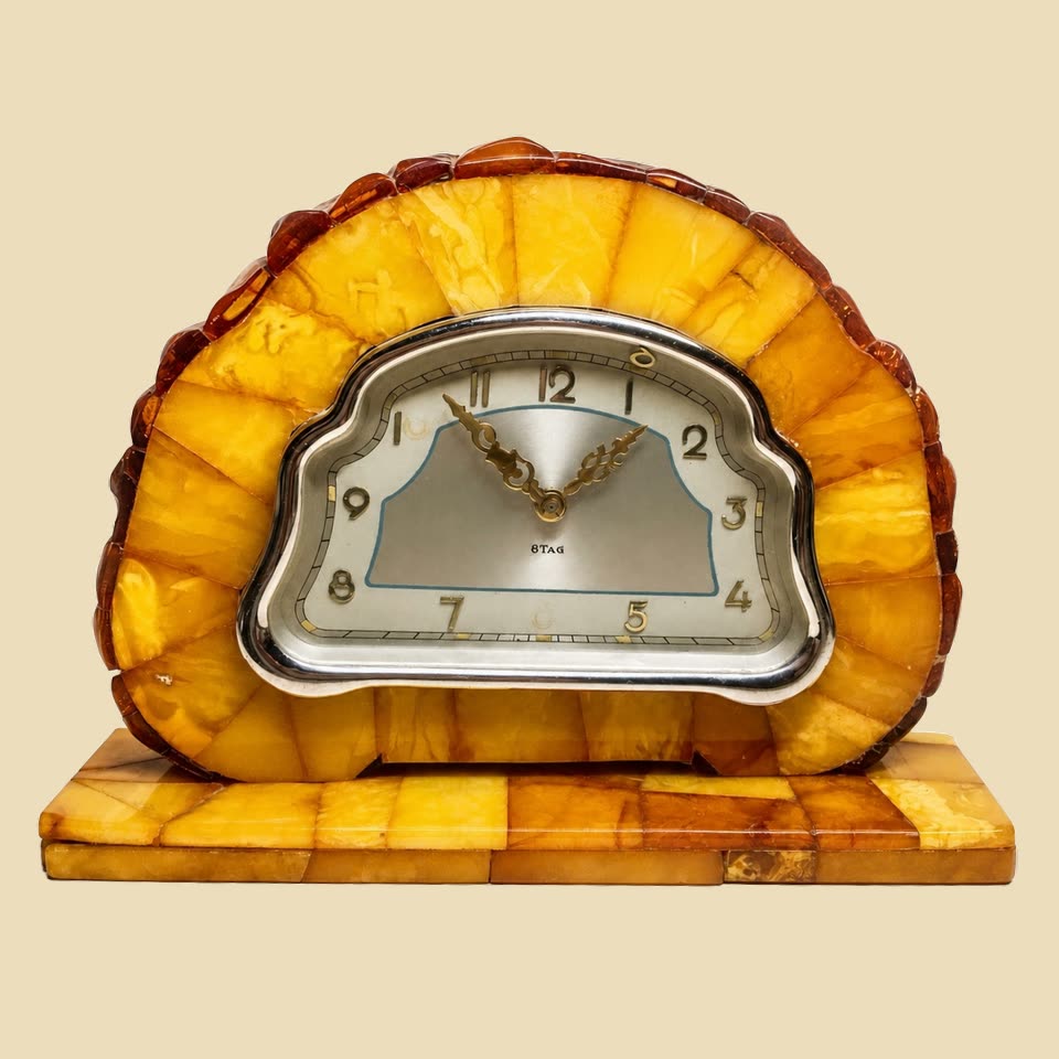 Antike SBM-Bernstein-Kaminuhr aus den 1930er-Jahren mit halbrundem Sonnenstrahl-Aufbau aus butterscotch-Bernstein-Tafeln, Silberzifferblatt-Rahmen, 8-Tage-Werk, klassisches Art-Deco-Stück der Staatlichen Bernstein-Manufaktur Ostpreußen, freigestellt