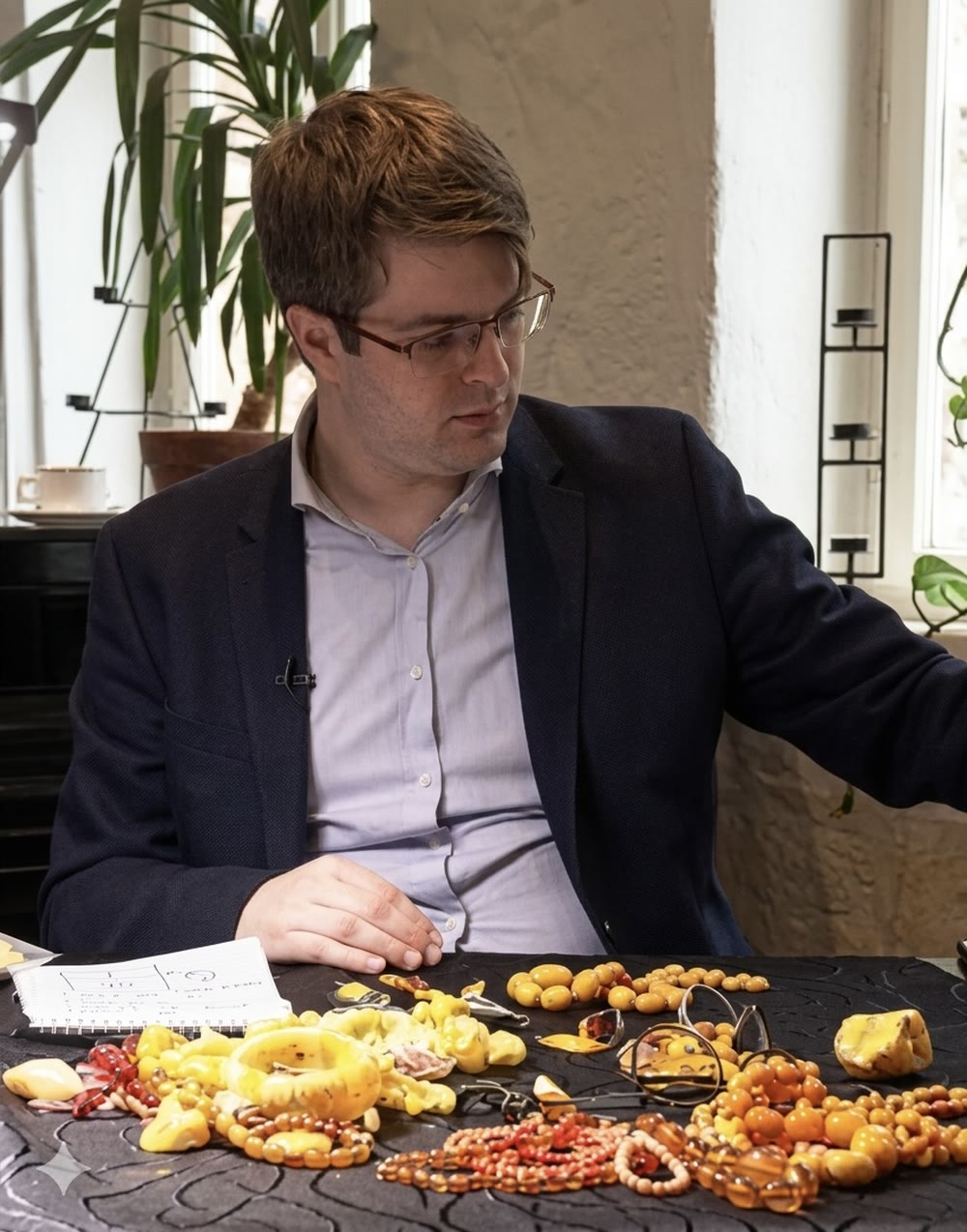 Marcel Querl im Interview als Bernsteinexperte, Aufnahme mit baltischem Bernsteinschmuck am Tisch