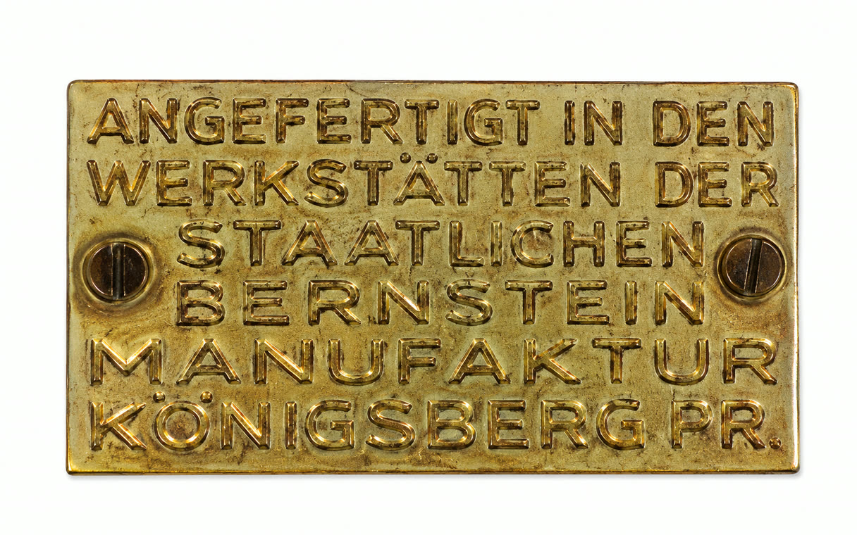 Original-Messingplakette eines SBM-Stücks mit Punz-Inschrift „Angefertigt in den Werkstätten der Staatlichen Bernstein Manufaktur Königsberg Pr.