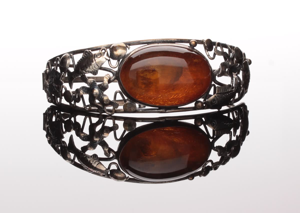 Antiker Fischland-Silberarmreif aus der Kramer-Schule mit ovalem Cognac-Cabochon, gefasst in figürliche Silberarbeit mit Ostsee-Motiven