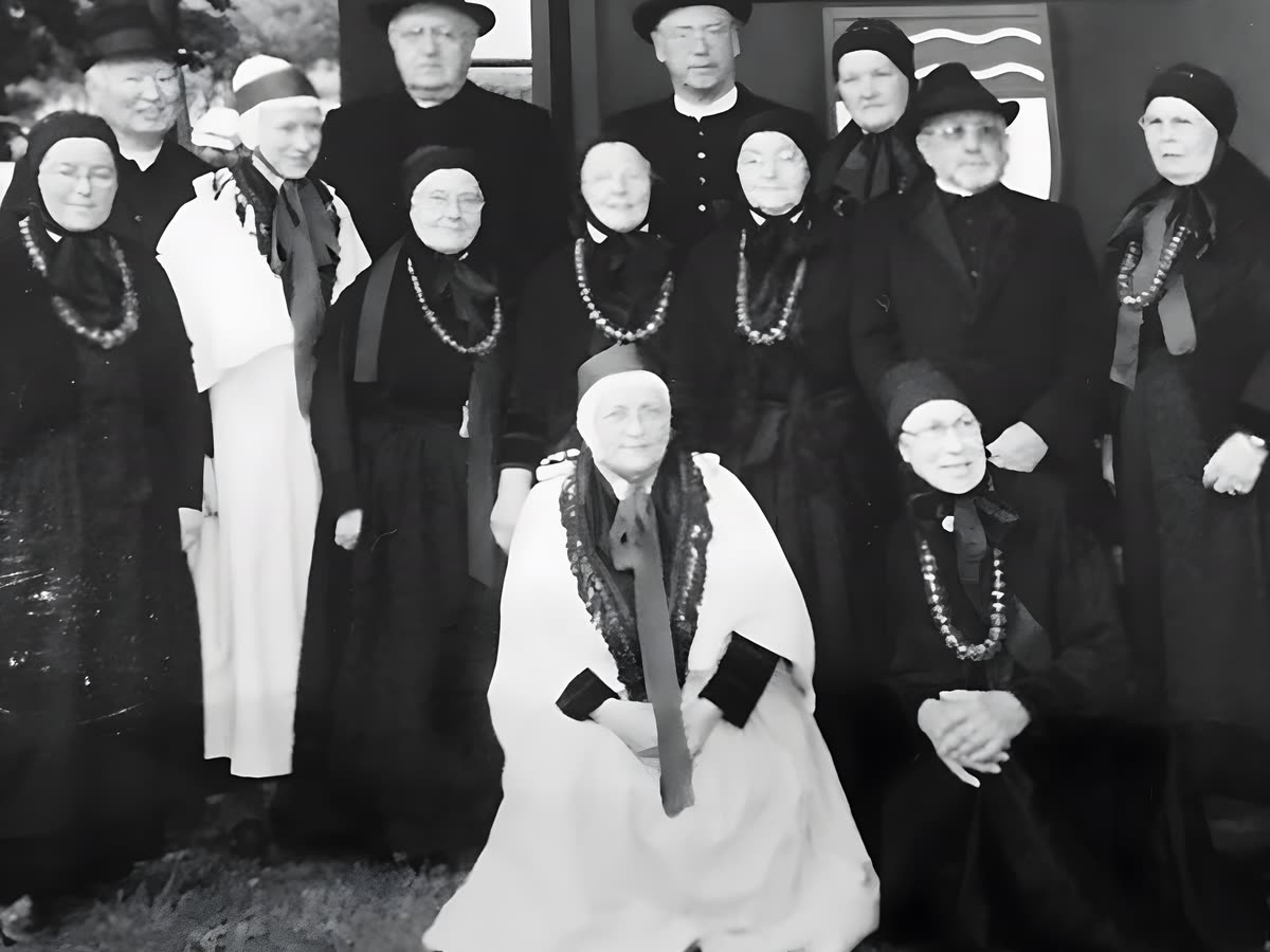 Historische Schwarzweiß-Gruppenaufnahme einer Trachten-Gesellschaft mit Frauen in Schaumburg-Lippischer Tracht und charakteristischen Bernstein-Trachtenketten